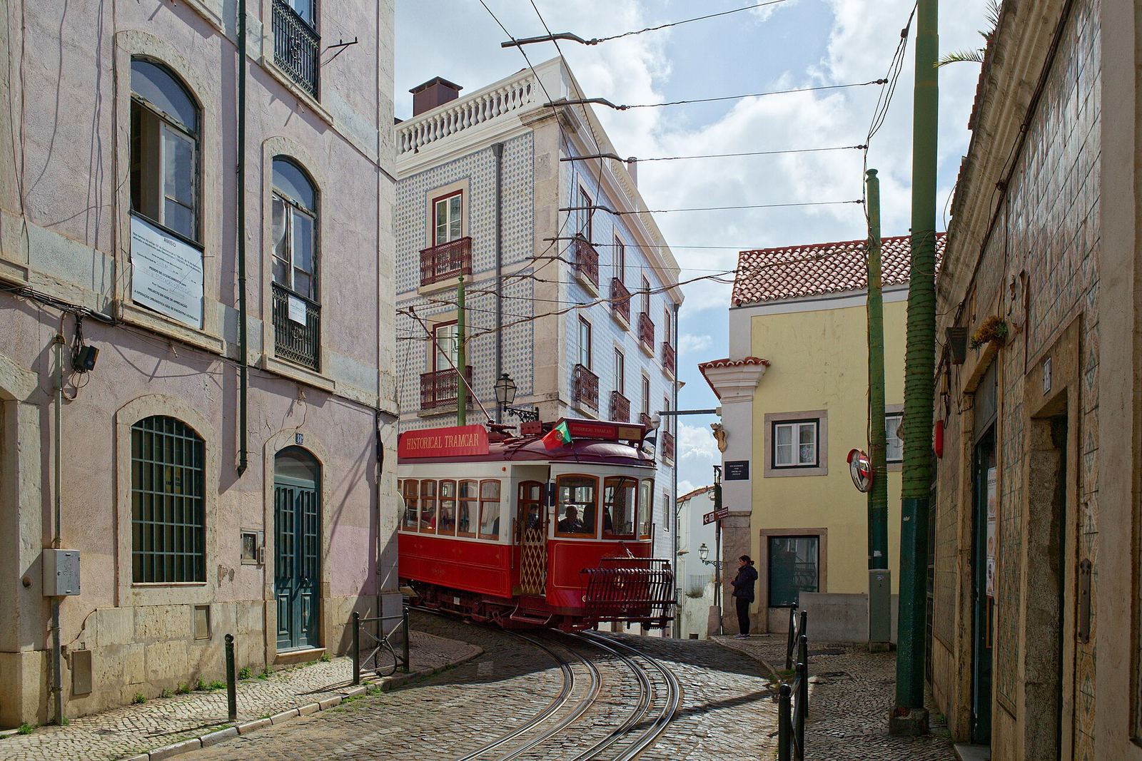 Tram 28 climbing a narrow street in Alfama, Lisbon